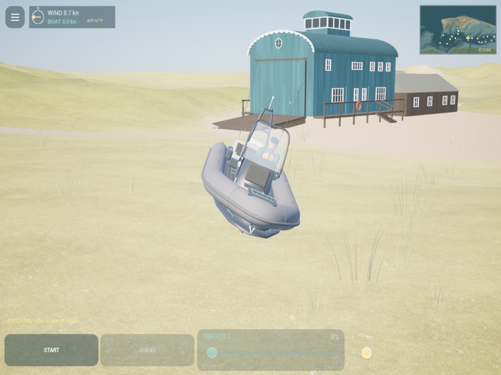 The RIB high and dry on grass beside a blue boathouse, with an aground warning